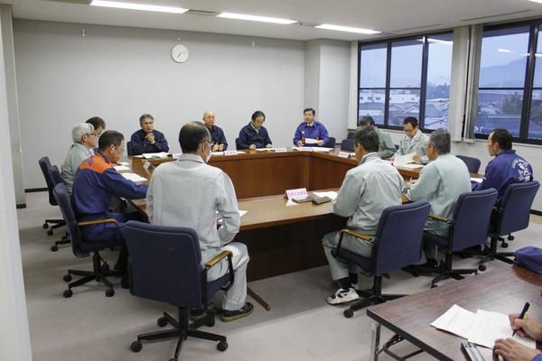 作業服姿の職員が、市長を交えて防災について話し合っている写真